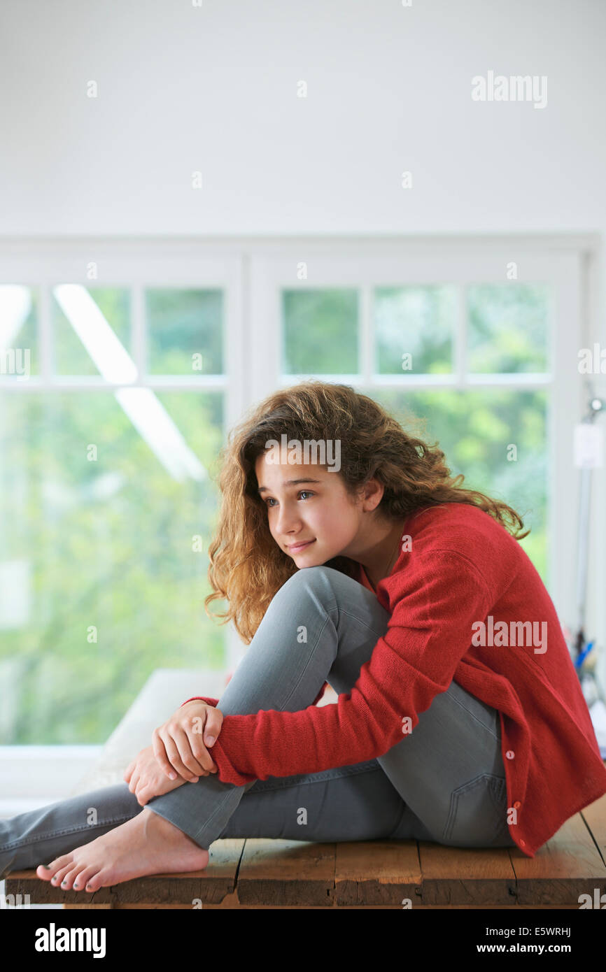 Ragazza giovane con capelli castani, appoggiato la testa sul ginocchio Foto Stock