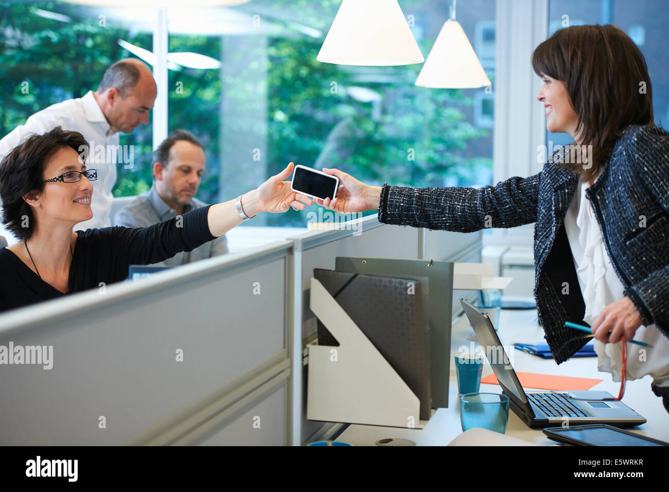 Donna smartphone passando a un collega Foto Stock