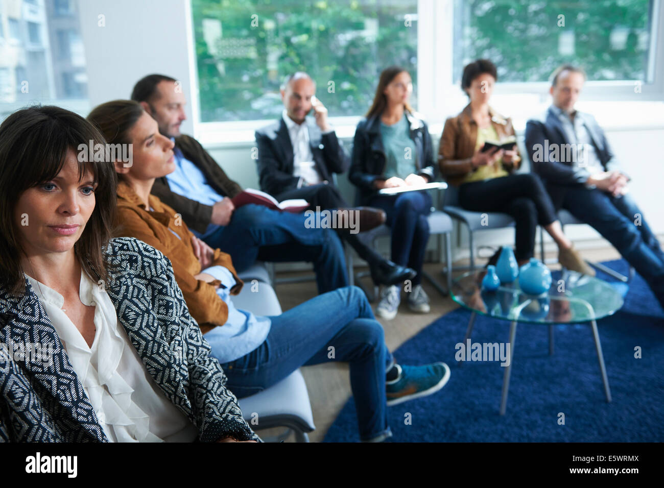 Persone sedute in sala d'attesa Foto Stock