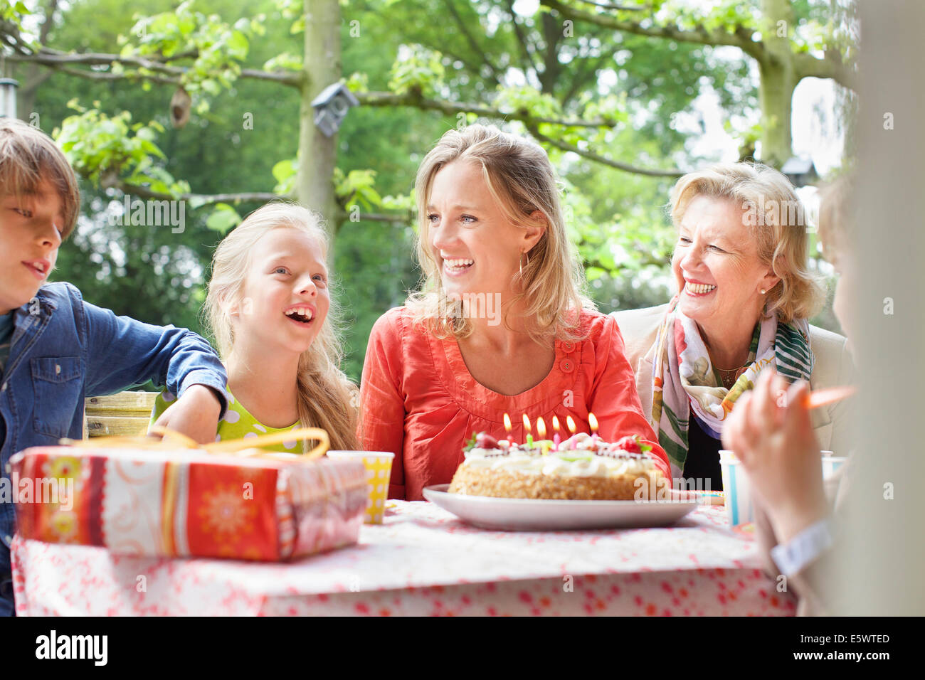 Ragazza rendendo desiderio di compleanno con la sua famiglia a festa di compleanno Foto Stock
