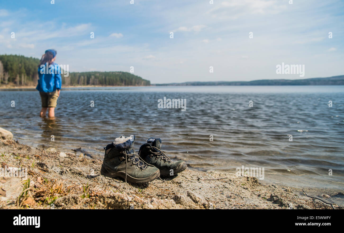 Metà femmina adulta escursionista prendendo una racchetta nel lago Foto Stock
