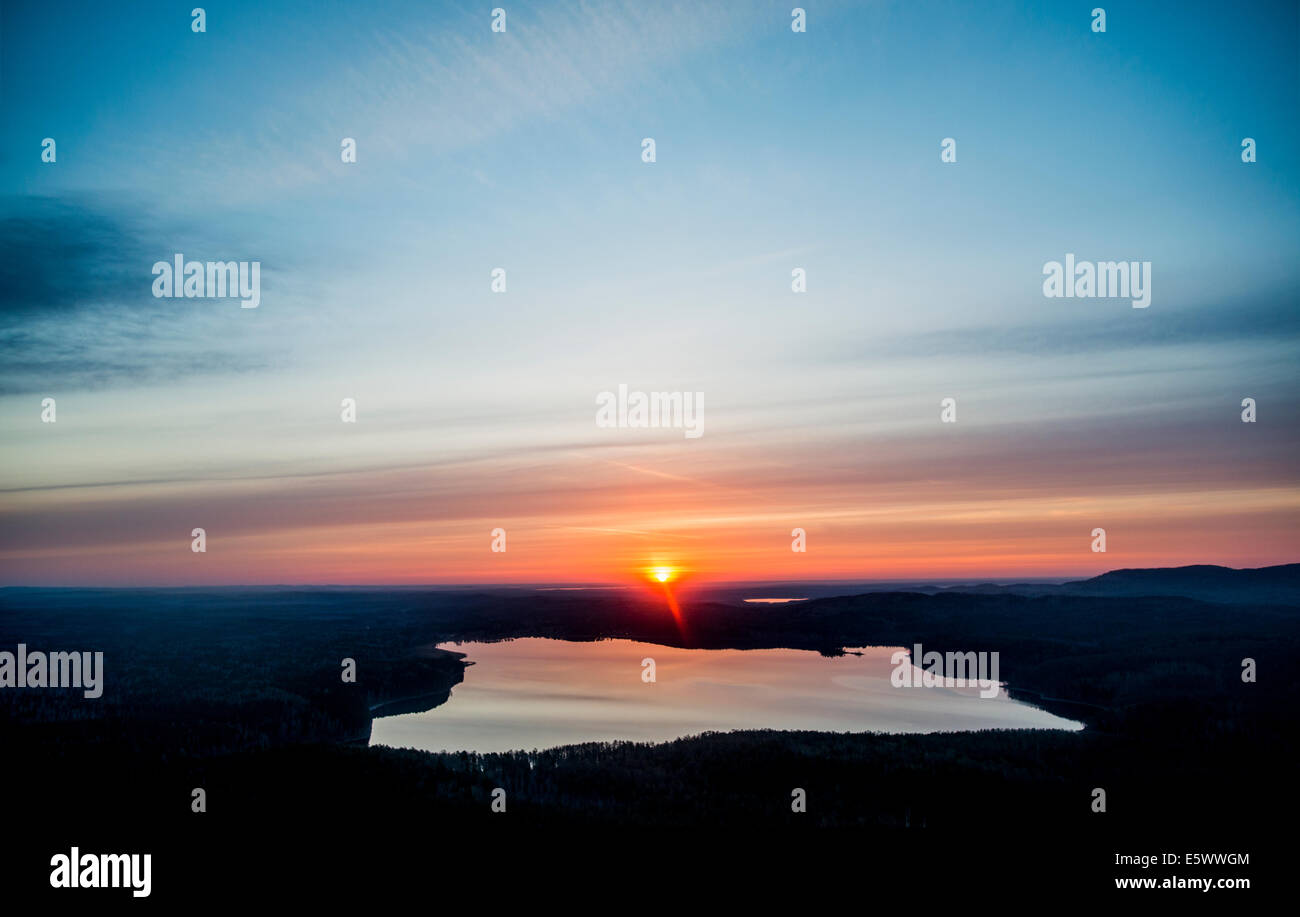 Vista di stagliano tramonto sul lago distante Foto Stock