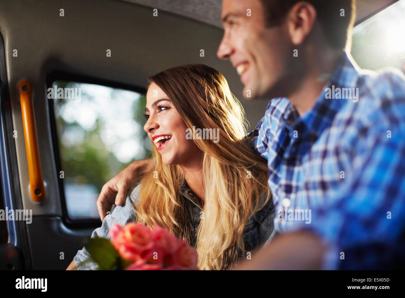 Giovane donna con il mio ragazzo e il mazzo di rose in città in taxi Foto Stock