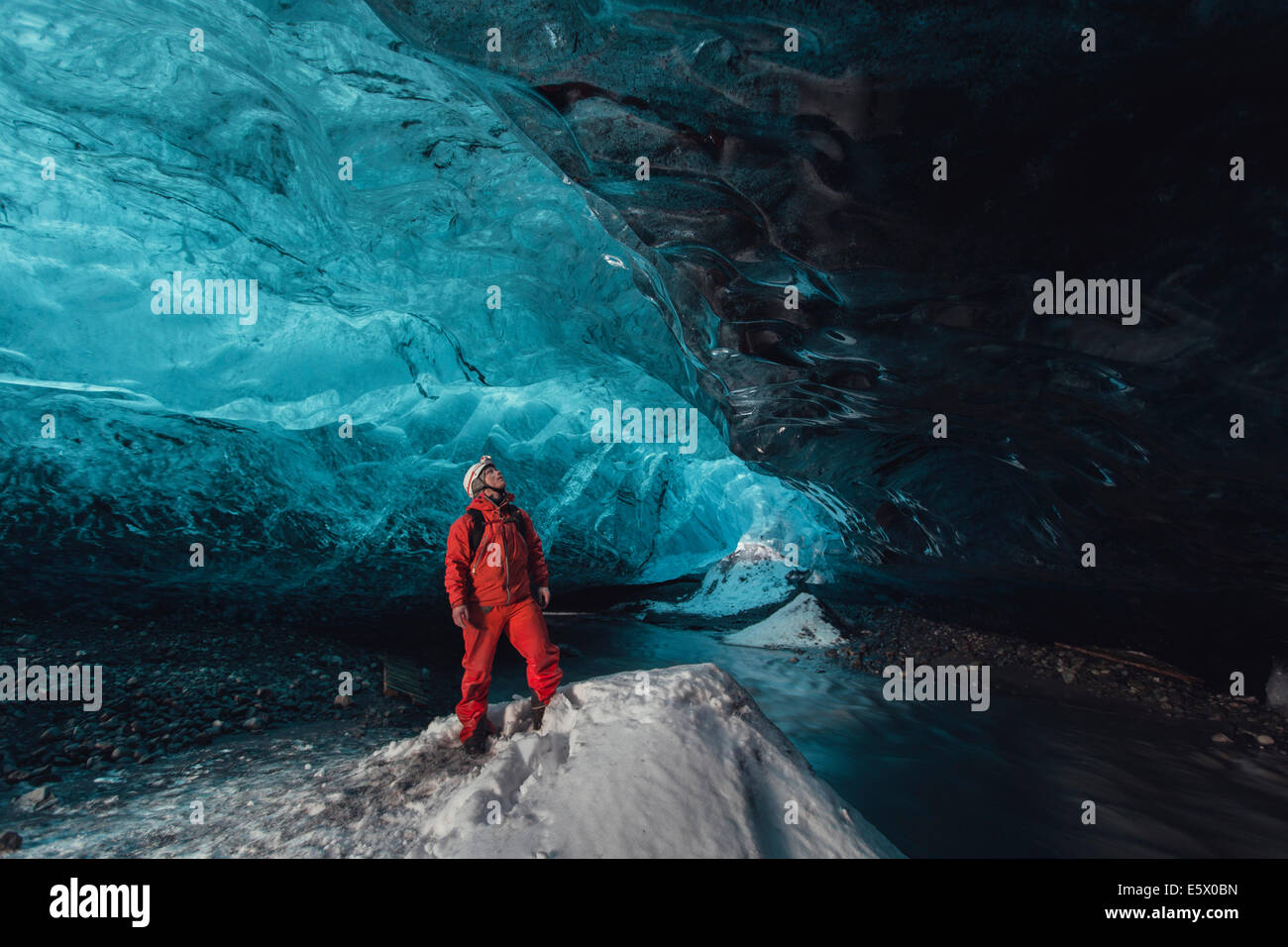 L'uomo guardando verso l'alto nella caverna di ghiaccio, ghiacciaio Vatnajokull, Vatnajokull National Park, Islanda Foto Stock