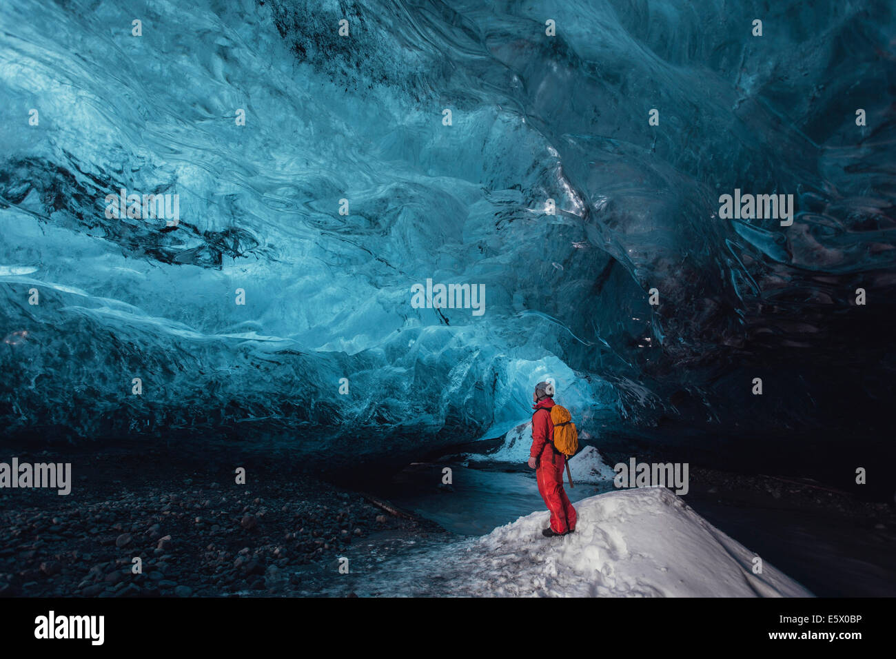 Uomo che guarda verso l'alto nella caverna di ghiaccio, ghiacciaio Vatnajokull, Vatnajokull National Park, Islanda Foto Stock