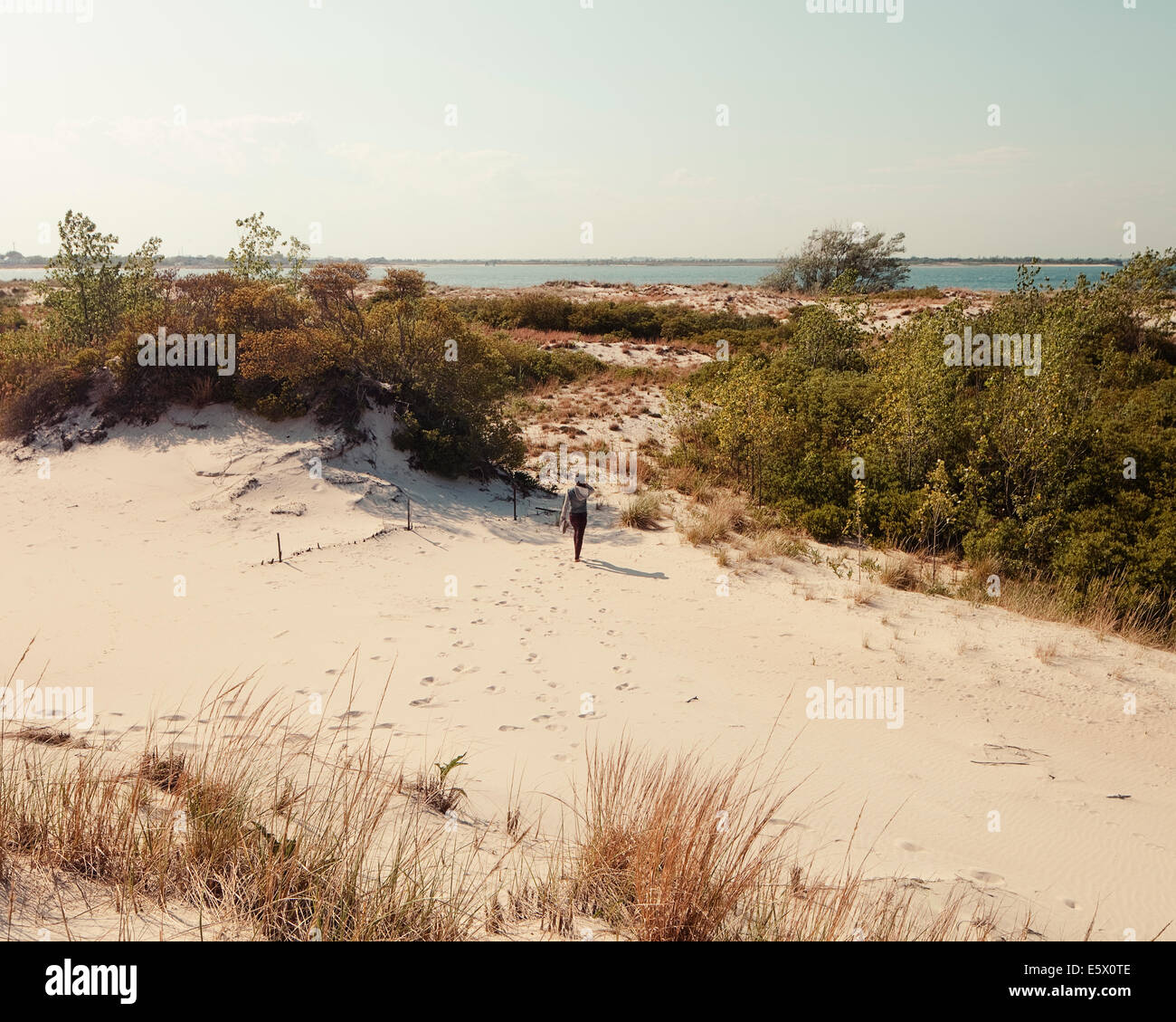 Metà donna adulta camminare su dune di sabbia, Jones Beach, nello Stato di New York, Stati Uniti d'America Foto Stock