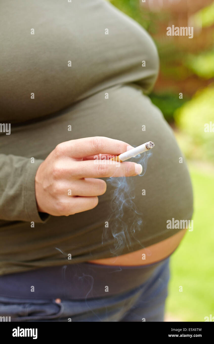 Donna incinta di fumare Foto Stock