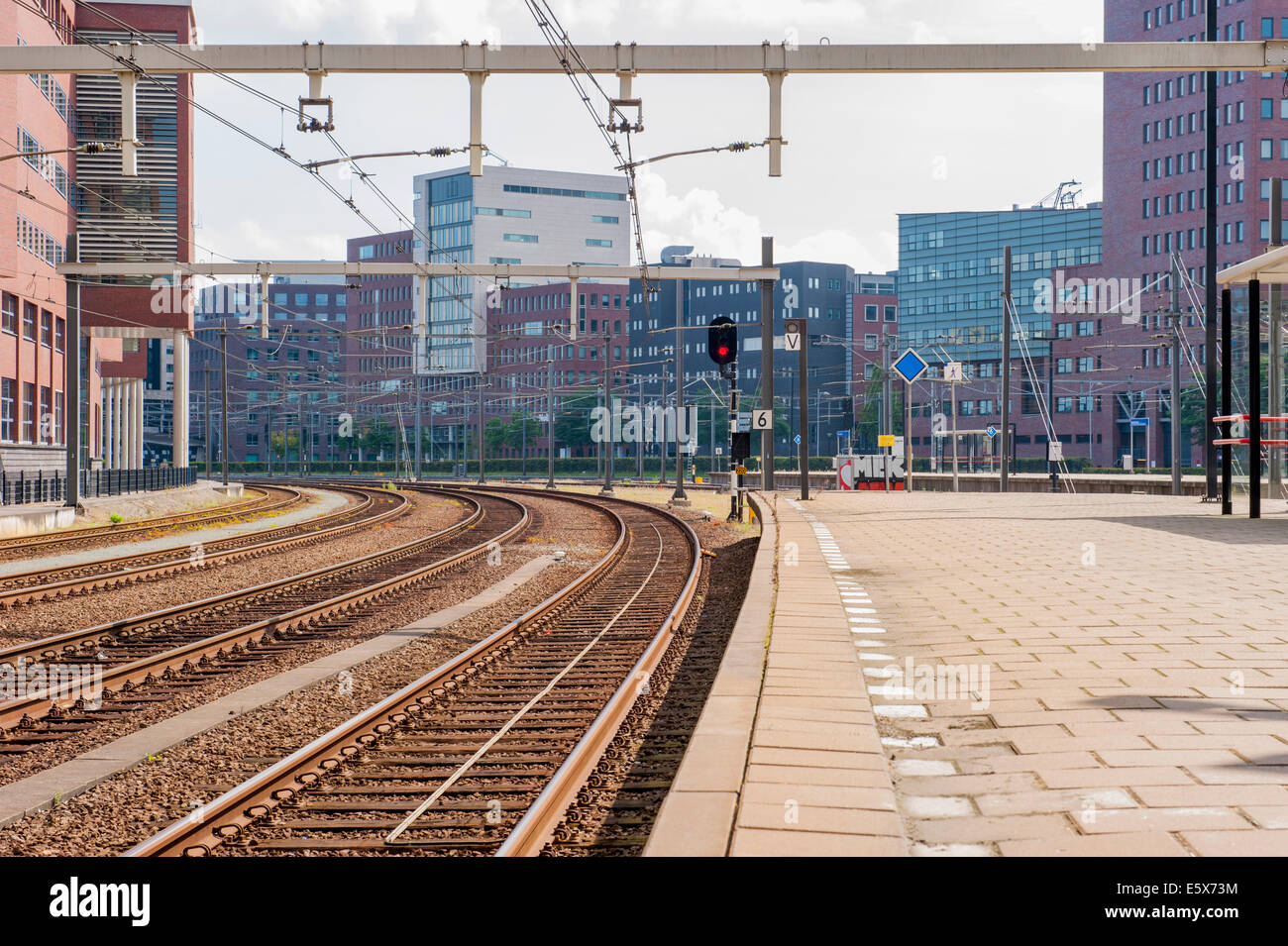 Piattaforma con binari ferroviari nel paesaggio urbano di edifici per uffici Foto Stock