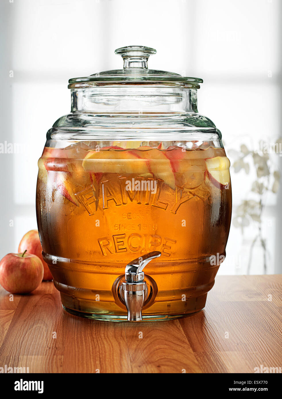 Il cilindro di vetro con rubinetto erogatore contenente fresco drink di Apple Foto Stock