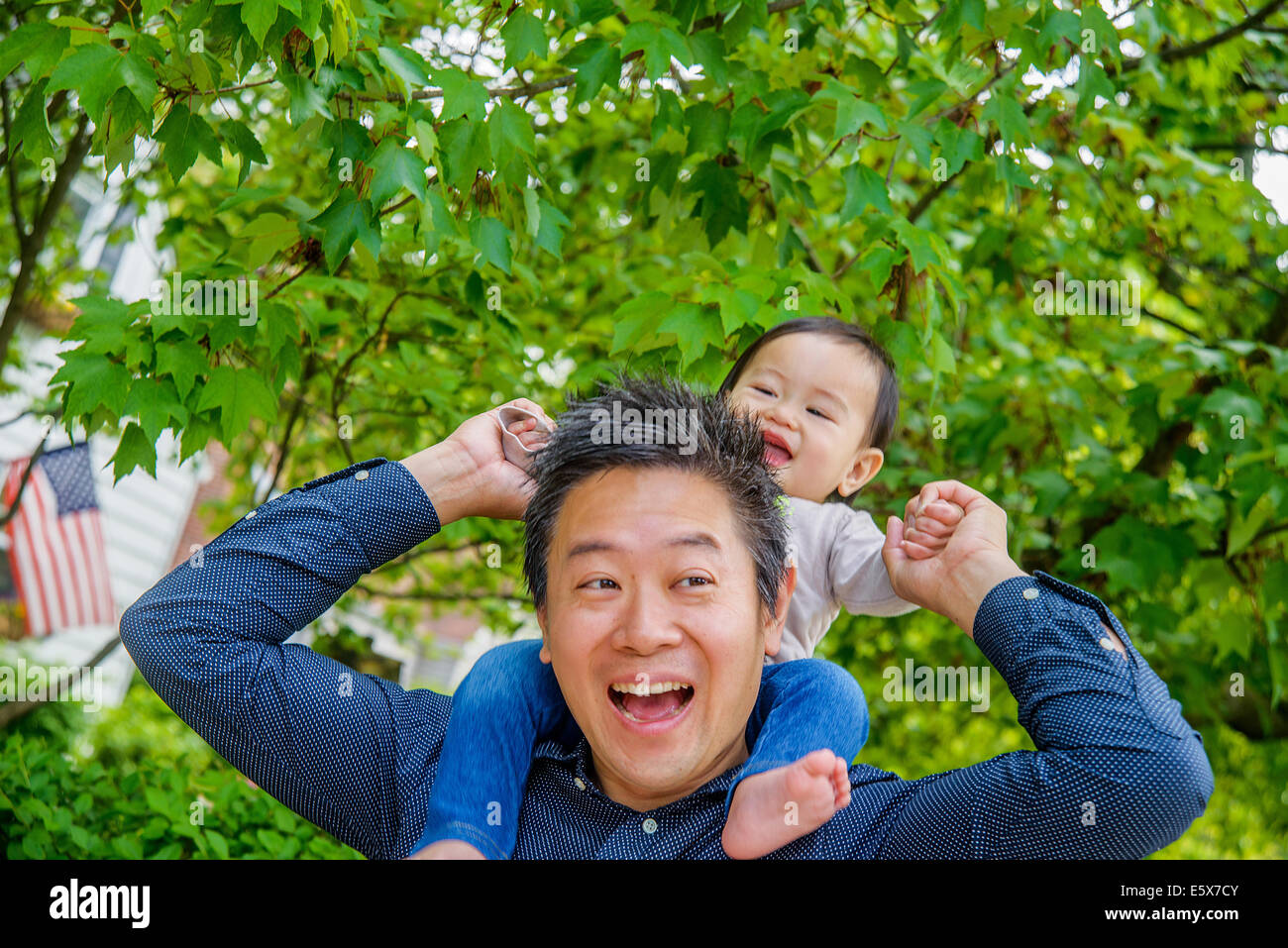 La metà degli adulti spalla padre bambino portando il figlio in giardino Foto Stock
