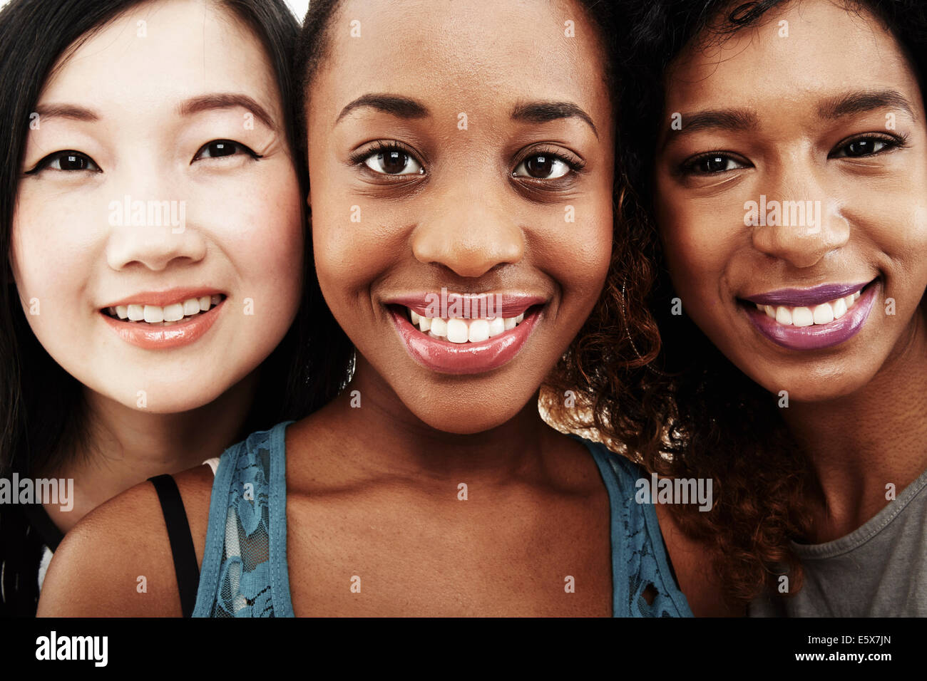 Close up ritratto in studio di tre sorridenti giovani donne Foto Stock