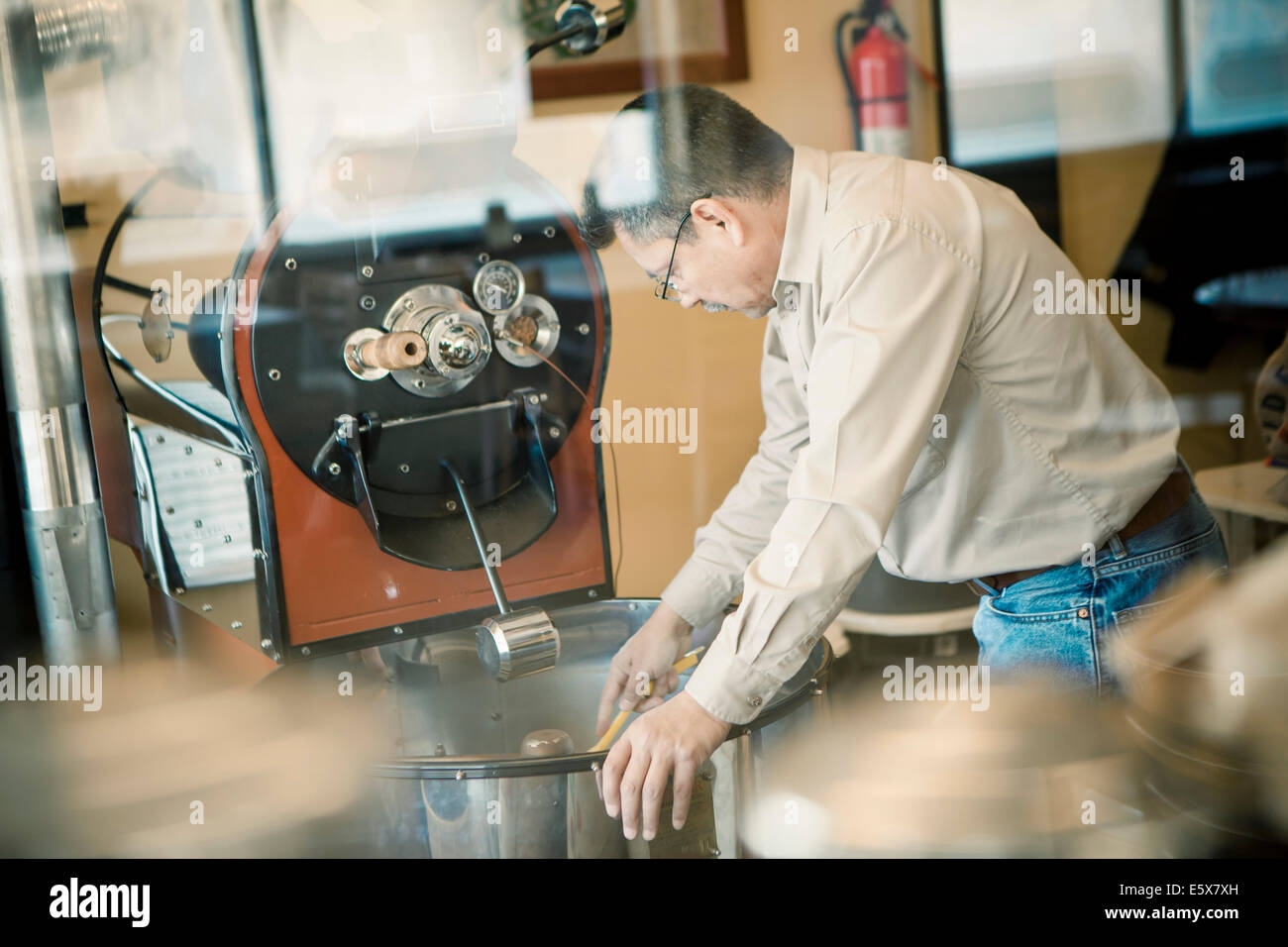 Uomo maturo con la tostatura del caffè macchina del caffè Foto Stock