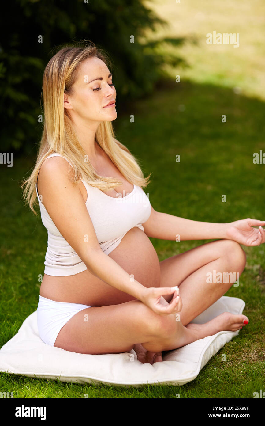 Donna incinta lo Yoga Foto Stock