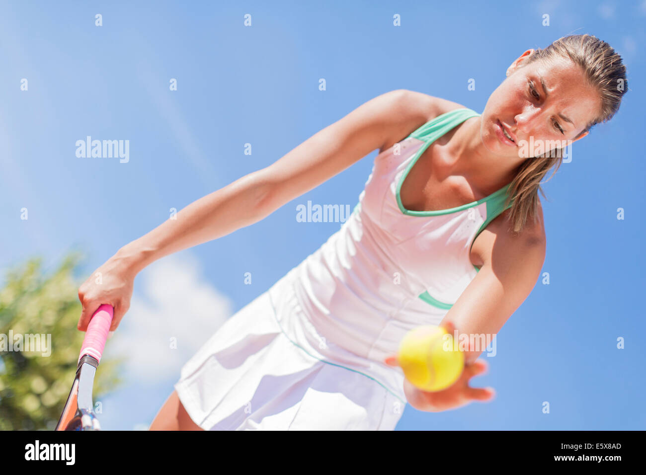 Giovane donna giocando a tennis Foto Stock