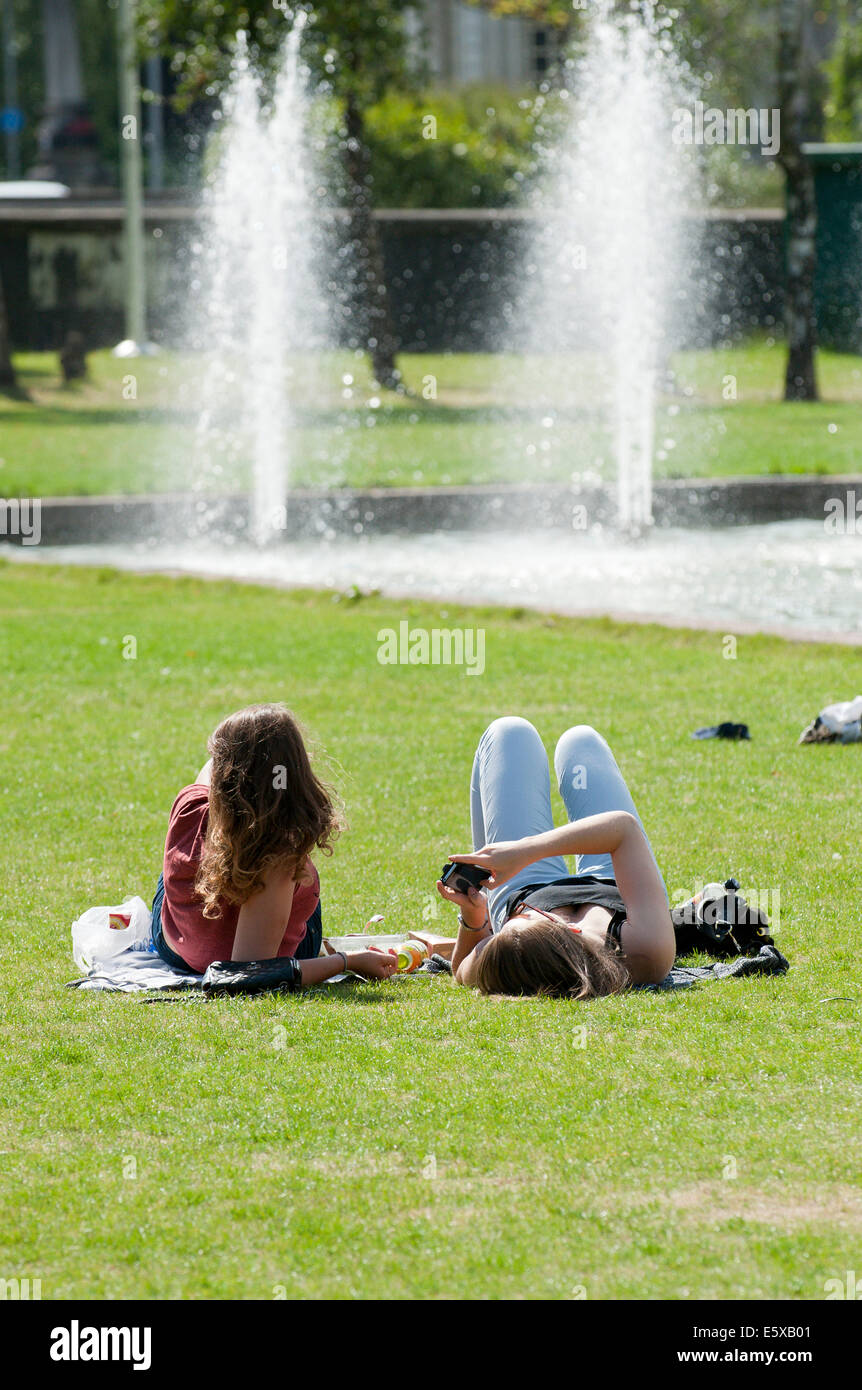 Cardiff, Glamorgan, Wales, Regno Unito. Il 7 agosto 2014. Le persone a rilassarsi in un giorno caldo da raffreddare una fontana di acqua a Cardiff. Credito: Graham M. Lawrence/Alamy Live News. Foto Stock