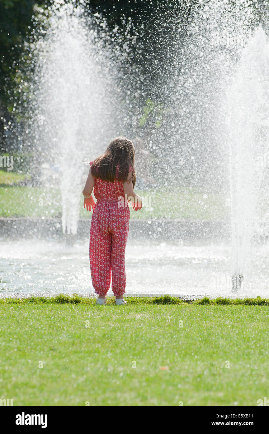 Cardiff, Glamorgan, Wales, Regno Unito. Il 7 agosto 2014. Le persone a rilassarsi in un giorno caldo da raffreddare una fontana di acqua a Cardiff. Credito: Graham M. Lawrence/Alamy Live News. Foto Stock