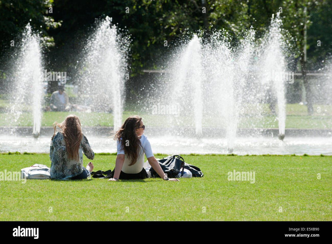 Cardiff, Glamorgan, Wales, Regno Unito. Il 7 agosto 2014. Le persone a rilassarsi in un giorno caldo da raffreddare una fontana di acqua a Cardiff. Credito: Graham M. Lawrence/Alamy Live News. Foto Stock