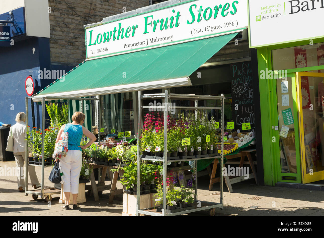 Esplorazione degli acquirenti a un frutto e negozio di fiori in Harrogate Town Center. Foto Stock