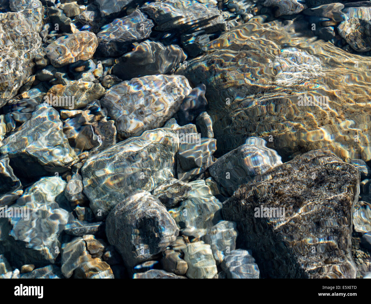 Abstract coloratissimi fondali bassi di increspature soleggiato sopra i ciottoli nel letto di ruscello, Scotland, Regno Unito Foto Stock