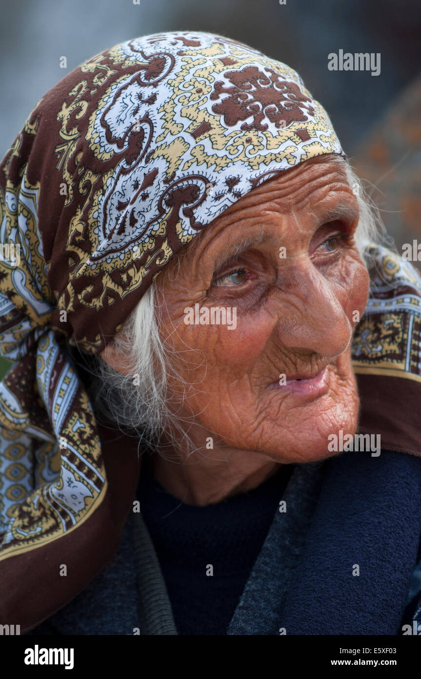 Vecchia donna con un espressione triste, noratus cimitero, Armenia Foto Stock