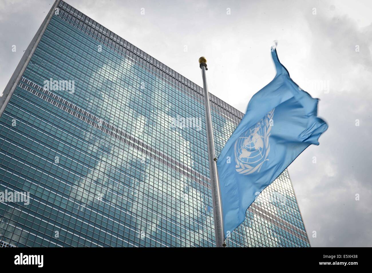 New York, Stati Uniti d'America. Il 7 agosto, 2014. La bandiera delle Nazioni Unite vola a metà in corrispondenza del montante dell'organizzazione di New York sulla sede 7 Agosto, 2014, in onore delle Nazioni Unite i membri dello staff ucciso nella Striscia di Gaza fin dall'inizio del conflitto quasi un mese fa. Credito: Niu Xiaolei/Xinhua/Alamy Live News Foto Stock