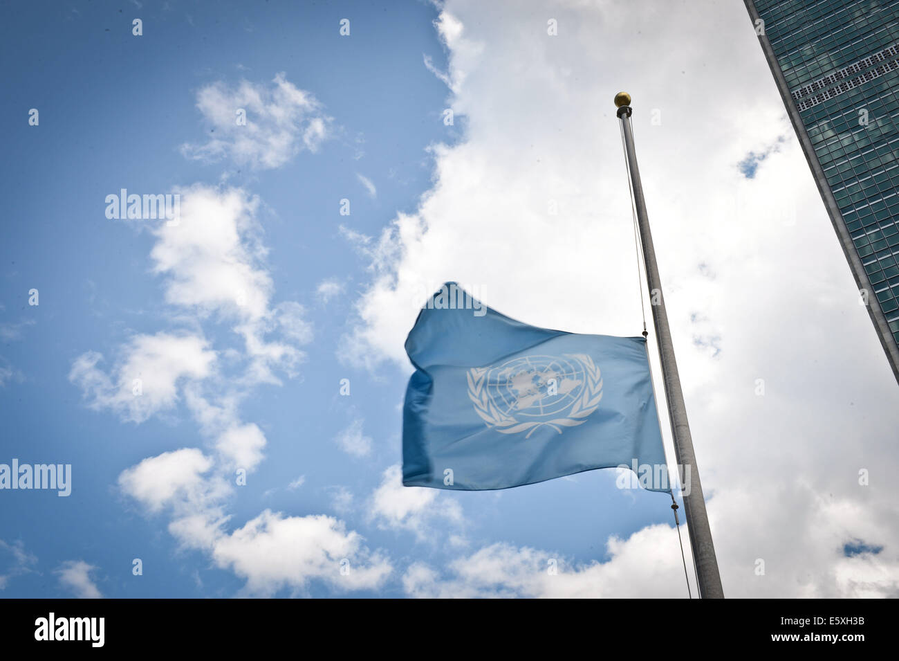New York, Stati Uniti d'America. Il 7 agosto, 2014. La bandiera delle Nazioni Unite vola a metà in corrispondenza del montante dell'organizzazione di New York sulla sede 7 Agosto, 2014, in onore delle Nazioni Unite i membri dello staff ucciso nella Striscia di Gaza fin dall'inizio del conflitto quasi un mese fa. Credito: Niu Xiaolei/Xinhua/Alamy Live News Foto Stock