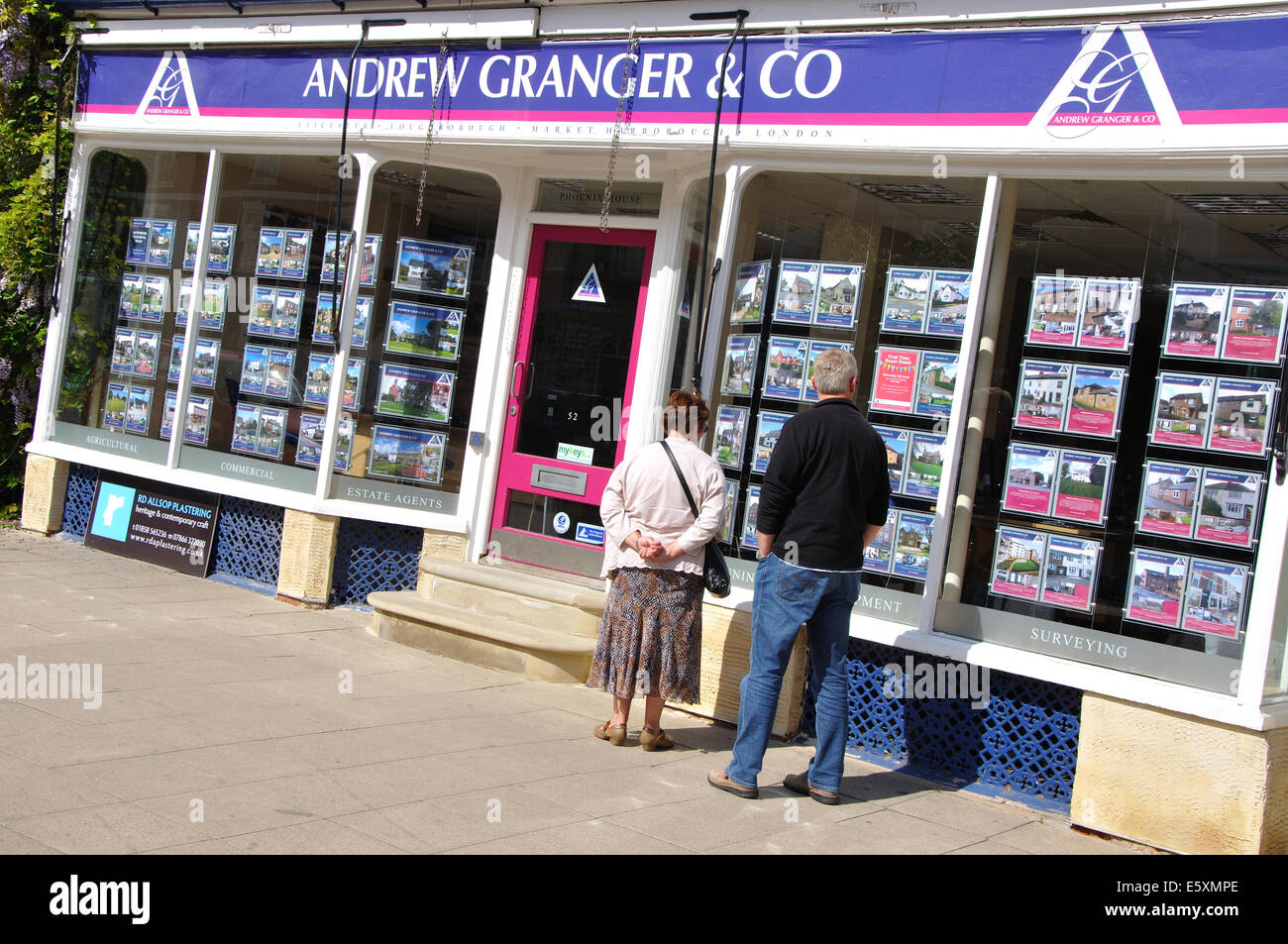 Coppia in cerca di agenti immobiliari finestra, Market Harborough, Leicestershire, England, Regno Unito Foto Stock