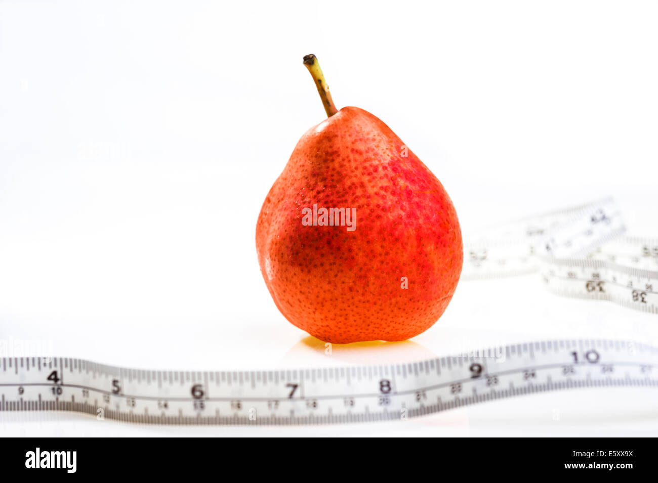 Pera rosso con nastro di misurazione.L'obesità, la perdita di peso, dieta. Foto Stock