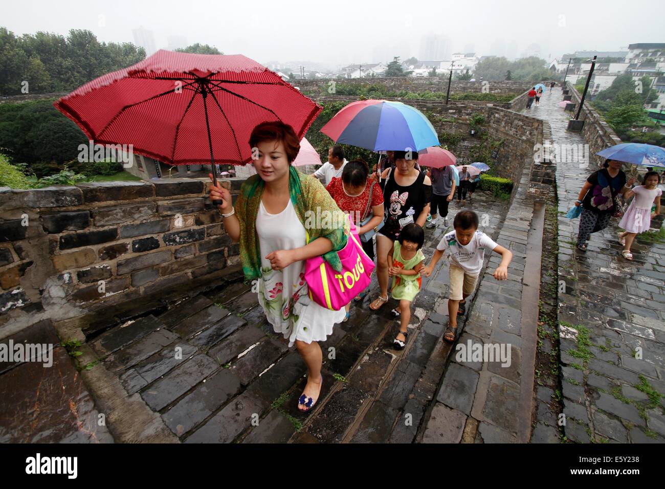 Nanjing. 8 Ago, 2014. Turisti visitano il Zhonghuamen Gate, a barbican che fa parte delle antiche mura della città di Nanjing, a est della capitale cinese della provincia di Jiangsu, e il Agosto 8, 2014. Nanjing della parete della città è stata costruita tra il 1366 e 1386, i primi anni della dinastia Ming (1368-1644). Una volta che la dinastia dei capitali propri Nanjing utilizzato per essere racchiuso da quattro strati di pietra-brick city walls. Dopo sei secoli di erosione naturale e distruzione umana a scopo, la lunghezza della restante parete della città di totali 25 chilometri di oggi, che fa ancora un record mondiale. © Xinhua/Alamy Live News Foto Stock