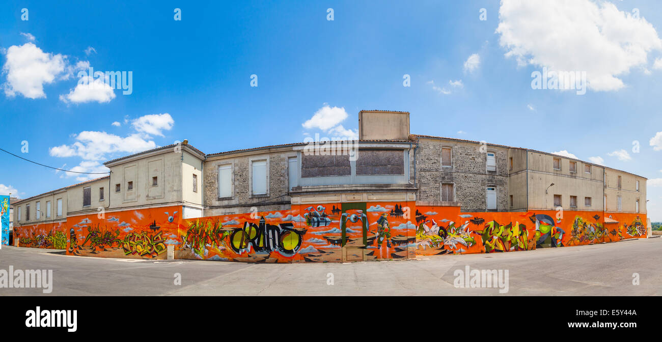 Grafitti che copre la parete inferiore sul retro del vecchio ospedale di Saintes. Foto Stock