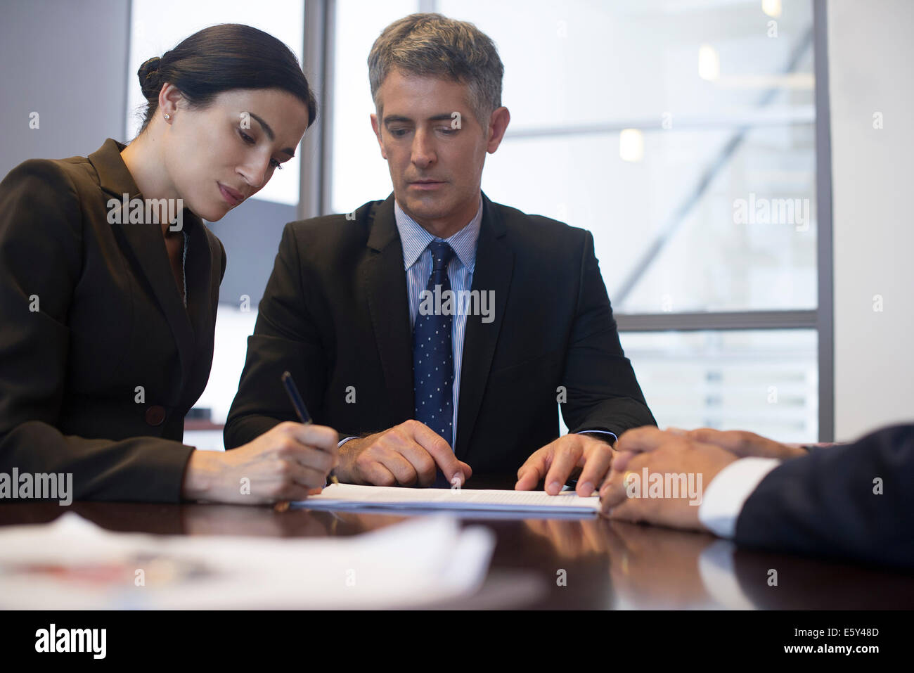 Business meeting, imprenditrice firma documento mentre associates osservare Foto Stock