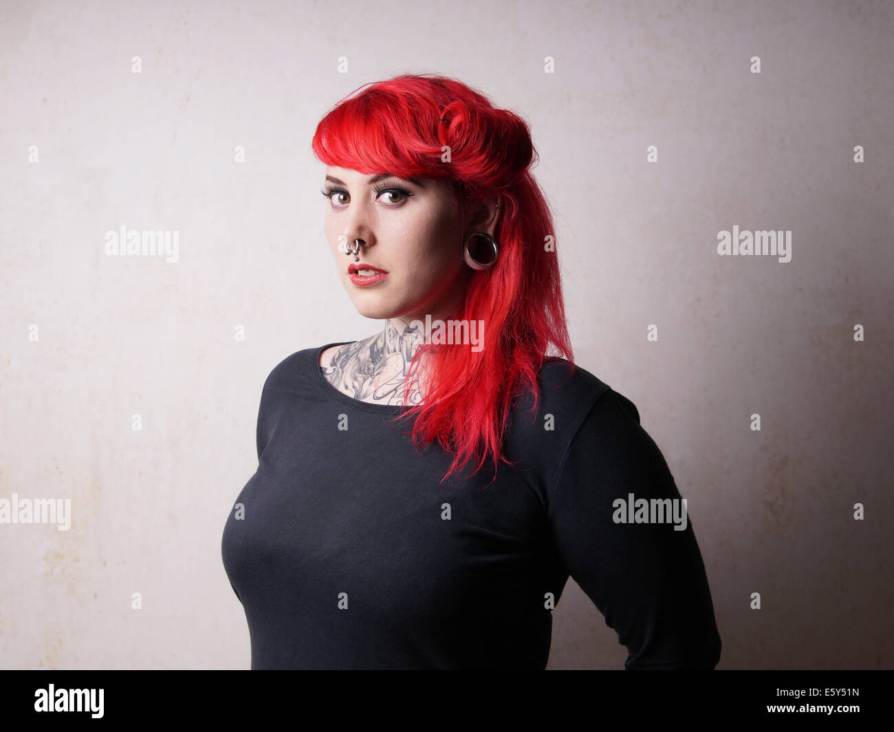 Giovane donna con piercing e tatuaggio Foto Stock