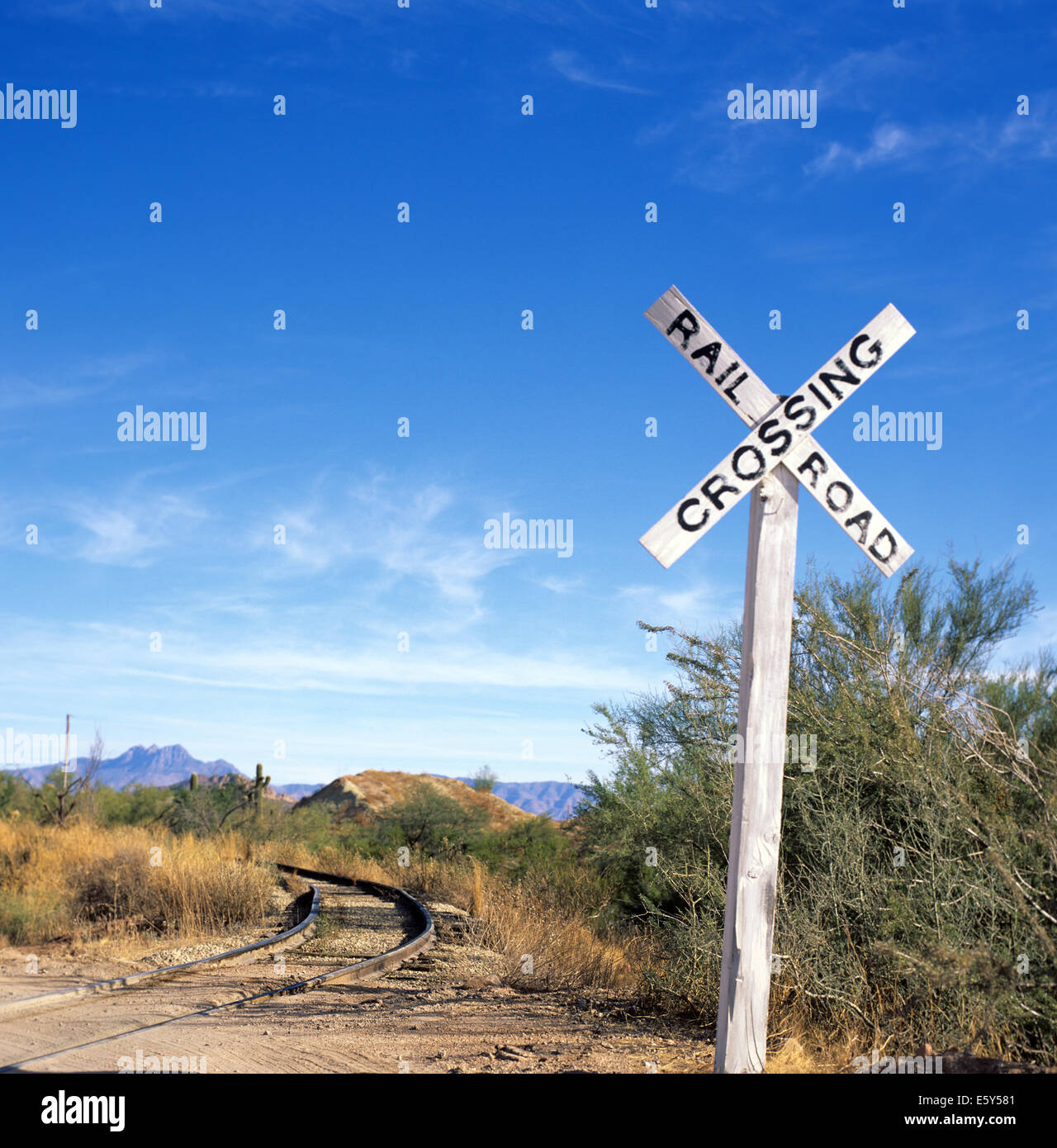Immagine di stock di un attraversamento ferroviario segno nel deserto dell'Arizona con brani in esecuzione dal segno. Foto Stock