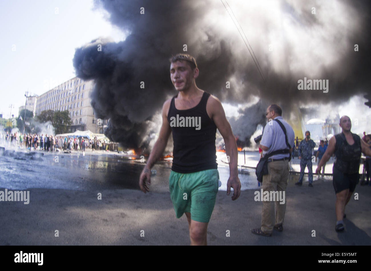 Gli attivisti pneumatici bruciati. Il 7 agosto, 2014. -- Gli attivisti e le forze di polizia hanno si scontrarono nella capitale ucraina il centro dopo i lavoratori comunali hanno cercato di smantellare il camp. Ne consegue un mese-vecchio conflitto sul campo con l'amministrazione della città. © Igor Golovniov/ZUMA filo/Alamy Live News Foto Stock