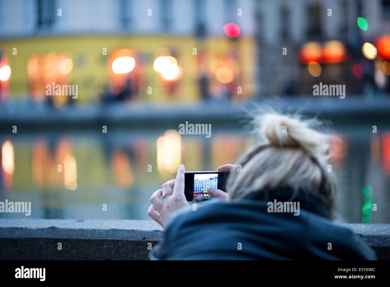 Donna che utilizza smartphone per la fotografia di scena della città Foto Stock