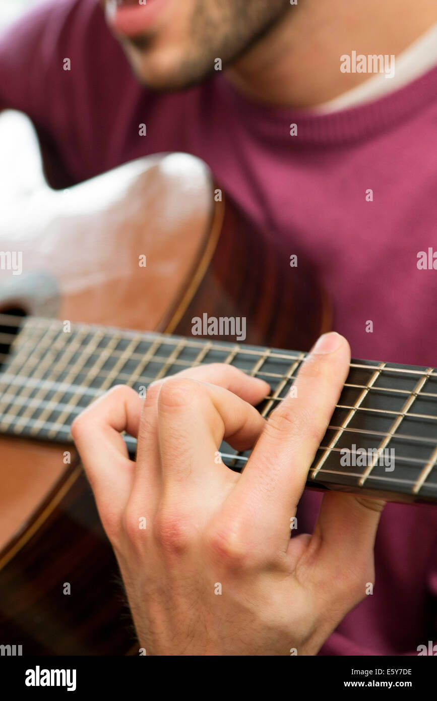 Giovane uomo suonare la chitarra acustica Foto Stock