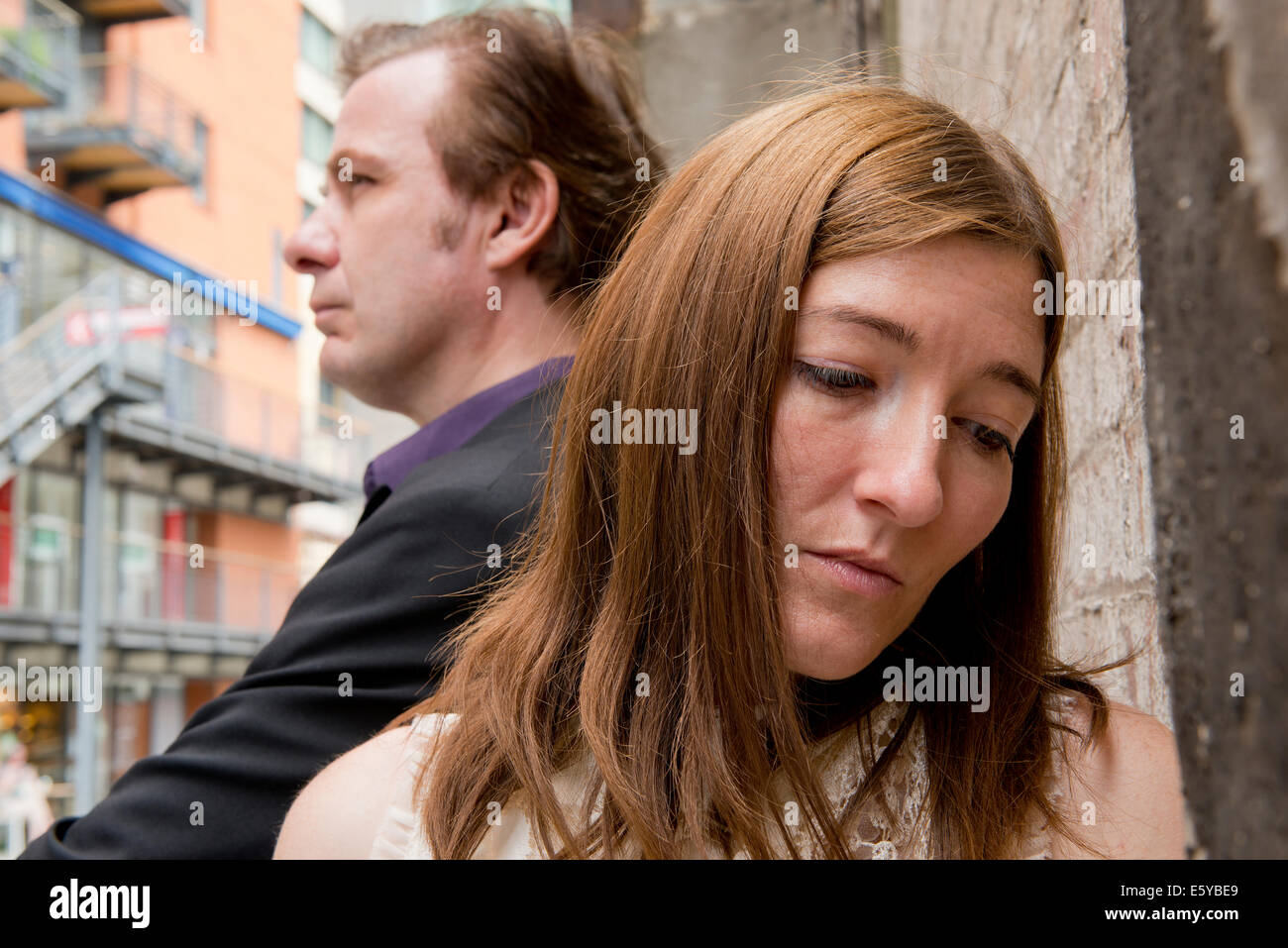 Donna infelice dando l'uomo dietro di lei la spalla a freddo. Foto Stock