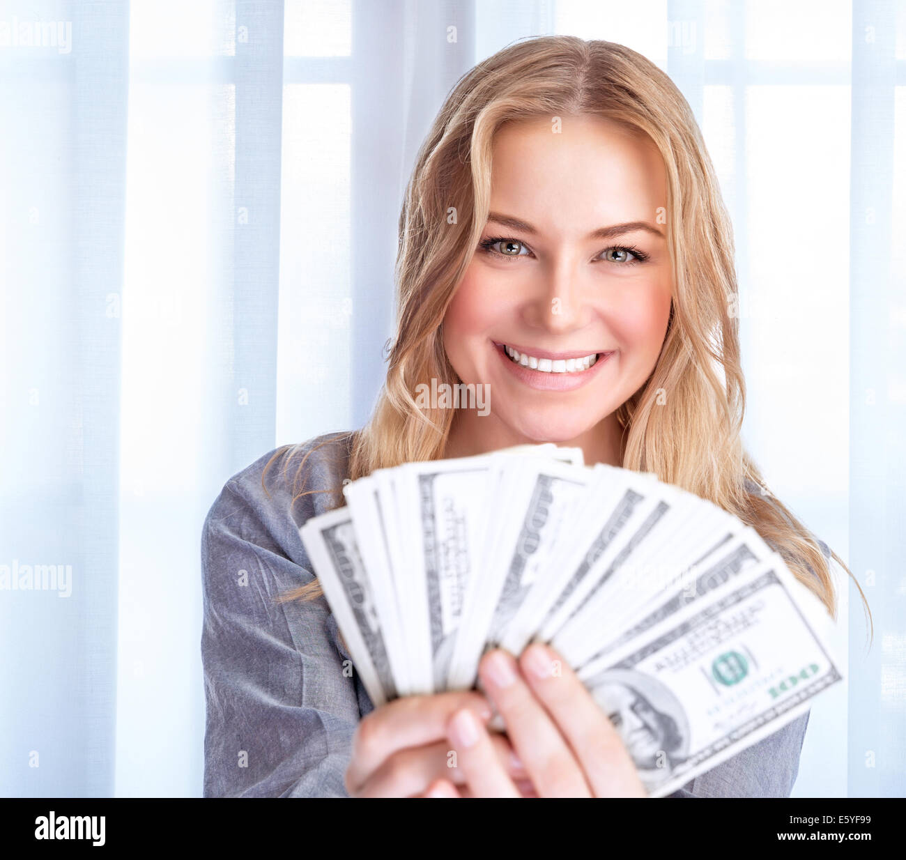 Ritratto di felice Excited donna tenendo in mano molti dollari, a casa il successo finanziario a spendere denaro, concetto di ricchezza Foto Stock