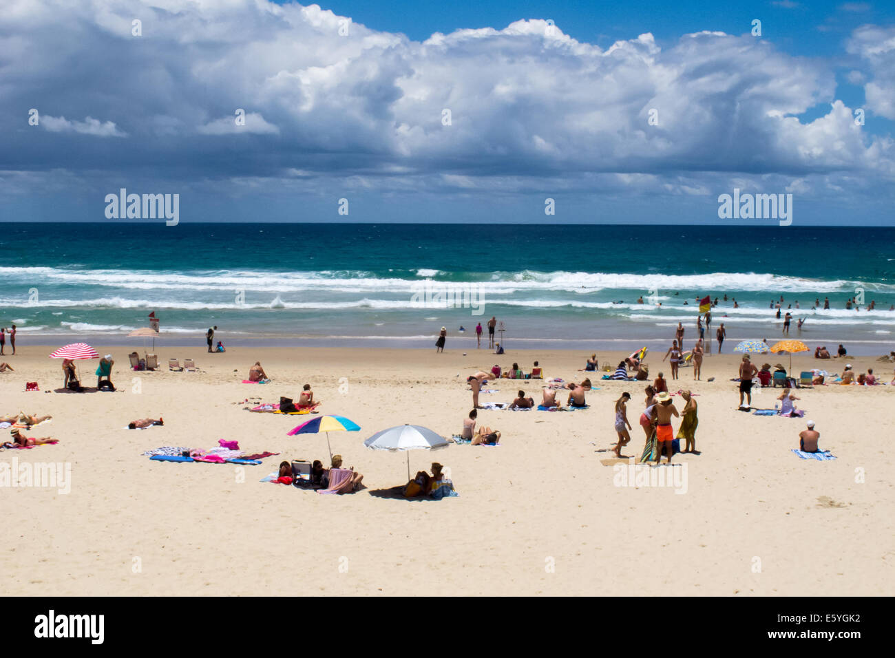 Gli amanti del sole per godersi la spiaggia e acqua sulla spiaggia principale sulla Gold Coast australiana Foto Stock