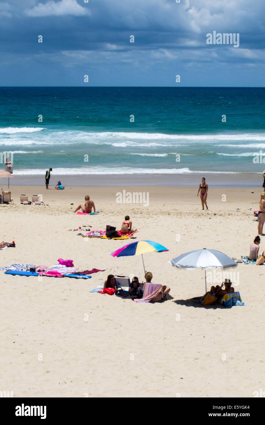 Gli amanti del sole per godersi la spiaggia e acqua sulla spiaggia principale sulla Gold Coast australiana Foto Stock