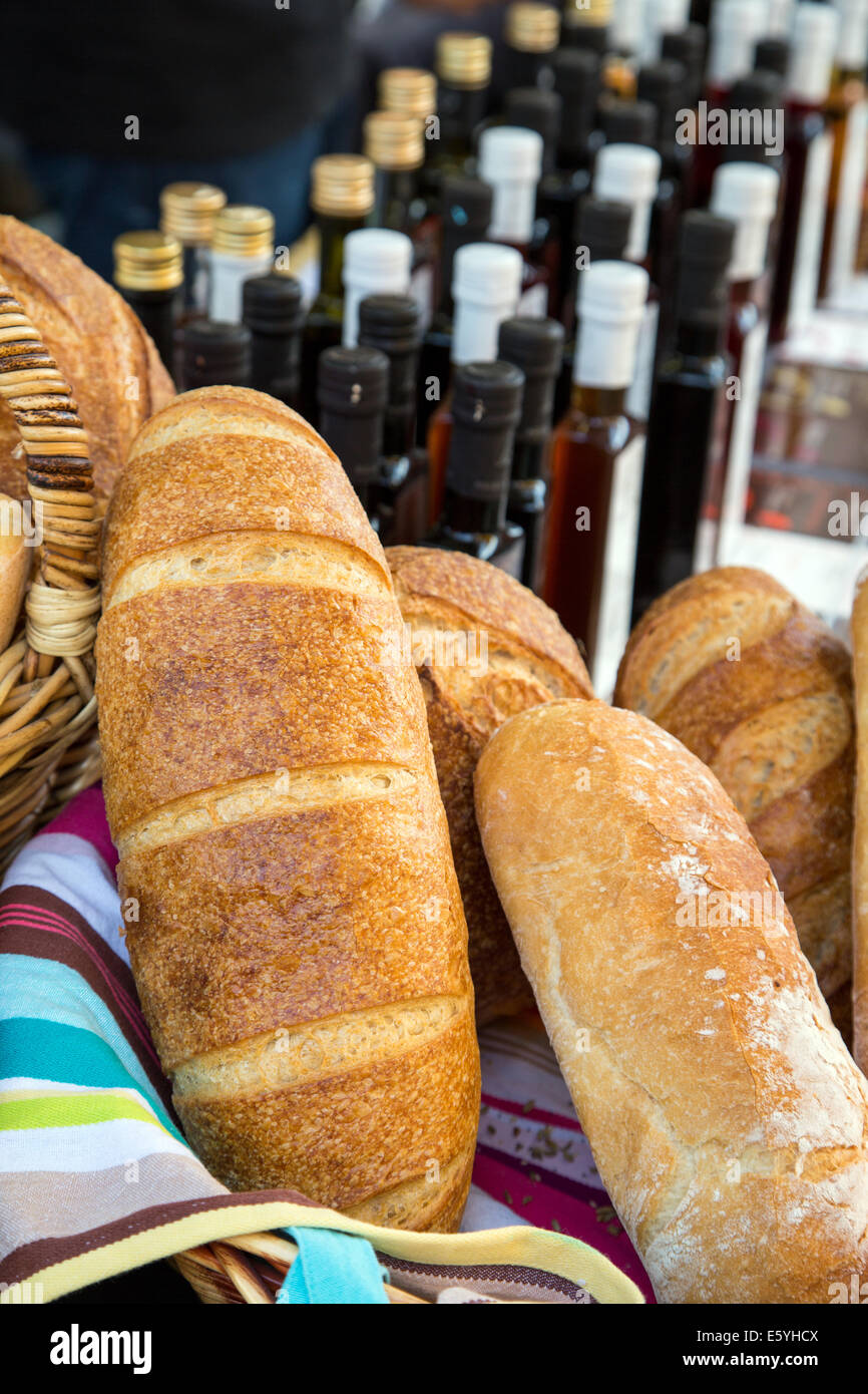 Crostini di pane in un cestino con delle bottiglie di vino in background. Foto Stock