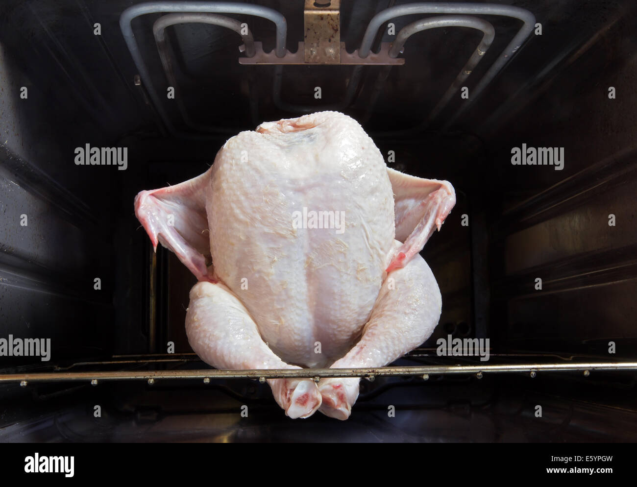 Il pollo crudo seduti in un forno Foto Stock