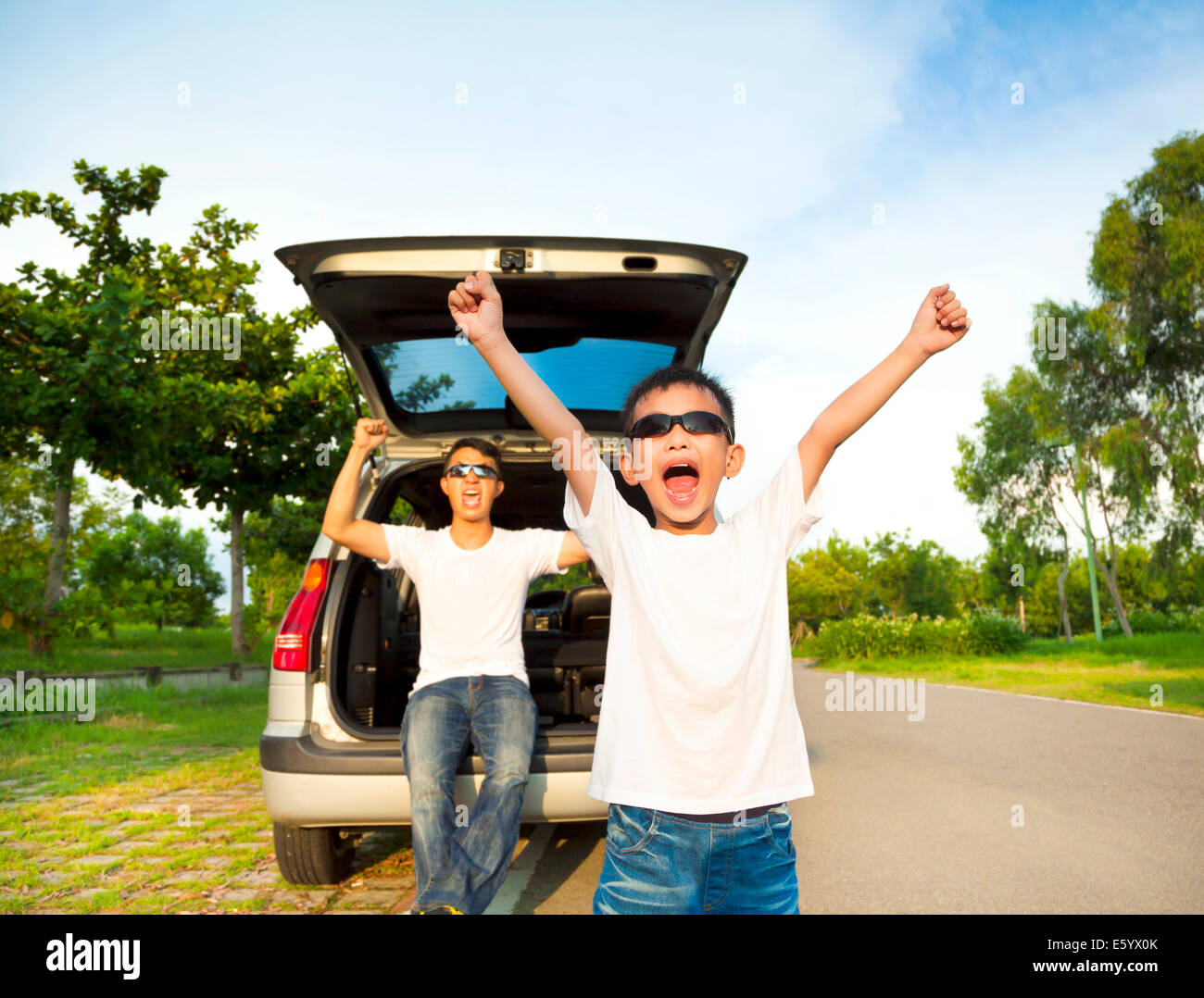 Dei bambini felici e padre bracci di sollevamento con le loro auto Foto Stock