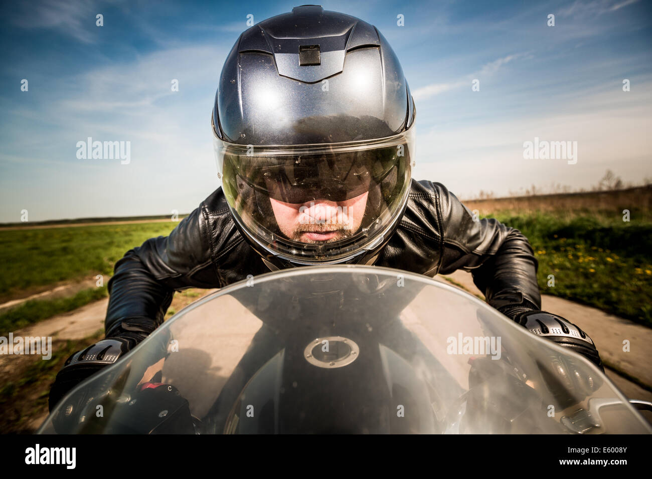 Biker in casco e giacca di pelle racing su strada Foto Stock Biker in casco e giacca di pelle racing su strada Foto Stock