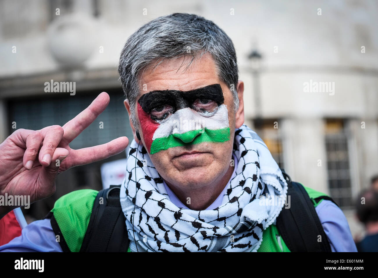 Portland Place, Londra, 9 agosto 2014. Un manifestante con una bandiera palestinese dipinto sul suo volto facendo un gesto di vittoria a una dimostrazione a sostegno di Gaza. Fotografo; Gordon Scammell/Alamy Live News Foto Stock