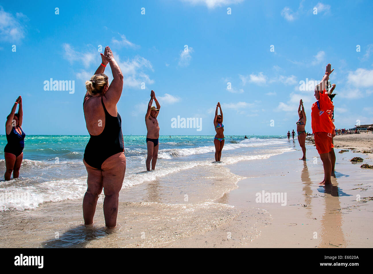 Africa, Nord Africa, il Maghreb, sud della Tunisia, Governorat di Medenine. Isola di Djerba. I turisti facendo ginnastica sulla spiaggia. Foto Stock