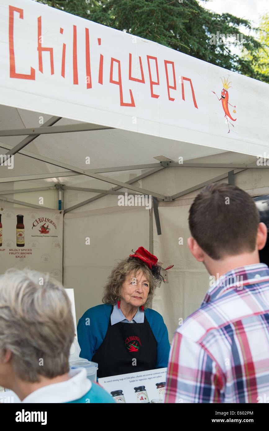 West Dean, Chichester, Regno Unito. Il 9 agosto, 2014. Il Chiliqueen completo con peperoncino Red Hat serve i clienti al suo stallo a il peperoncino Fiesta a West Dean, Agosto 2014. Regno Unito meteo. Credito: MeonStock/Alamy Live News Foto Stock