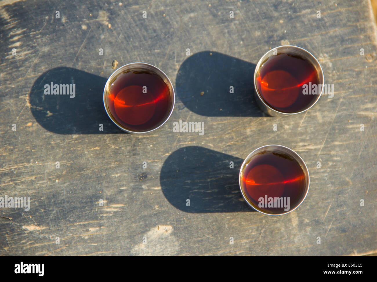 Tre bicchieri di alcol su una tavola di legno Foto Stock