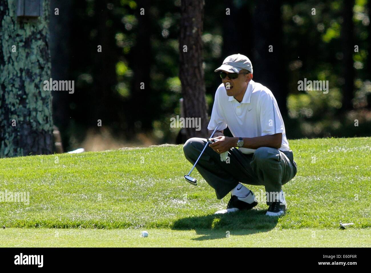 Oak Bluffs, Massachusetts, STATI UNITI D'AMERICA. Il 9 agosto, 2014. Il Presidente degli Stati Uniti Barack Obama linee fino un putt sul primo green presso la fattoria collo Golf Club in Oak Bluffs, Massachusetts, Stati Uniti, sabato 9 agosto 2014. Il Presidente arrivati sull'isola oggi e che è in vacanza per due settimane. Credito: Matthew Healey/Piscina via CNP - NESSUN SERVIZIO DI FILO- Credito: dpa/Alamy Live News Foto Stock