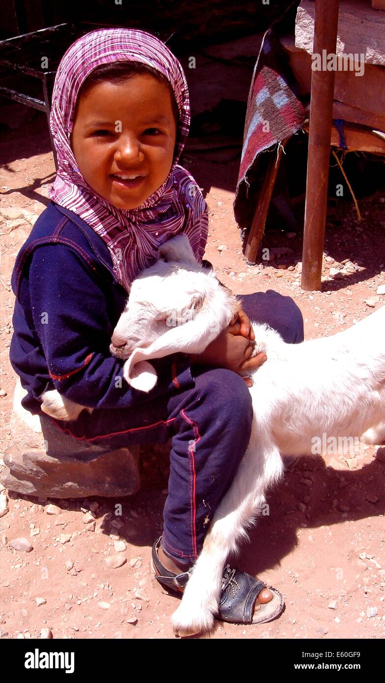 Una ragazza con il suo animale domestico di capra, vicino alla città di Petra, Giordania Foto Stock